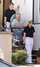 Foto: Älterer Herr wird auf Trage aus dem Haus getragen