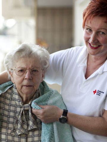Foto: Pflegerin hilft Seniorin